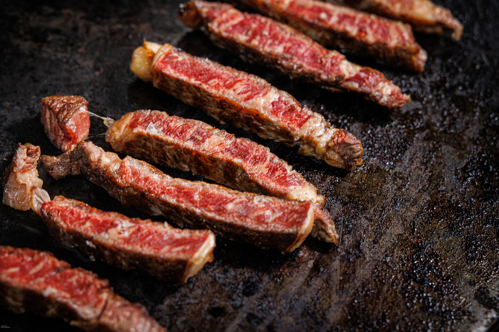 Fette di carne alla brace su piastra di pietra