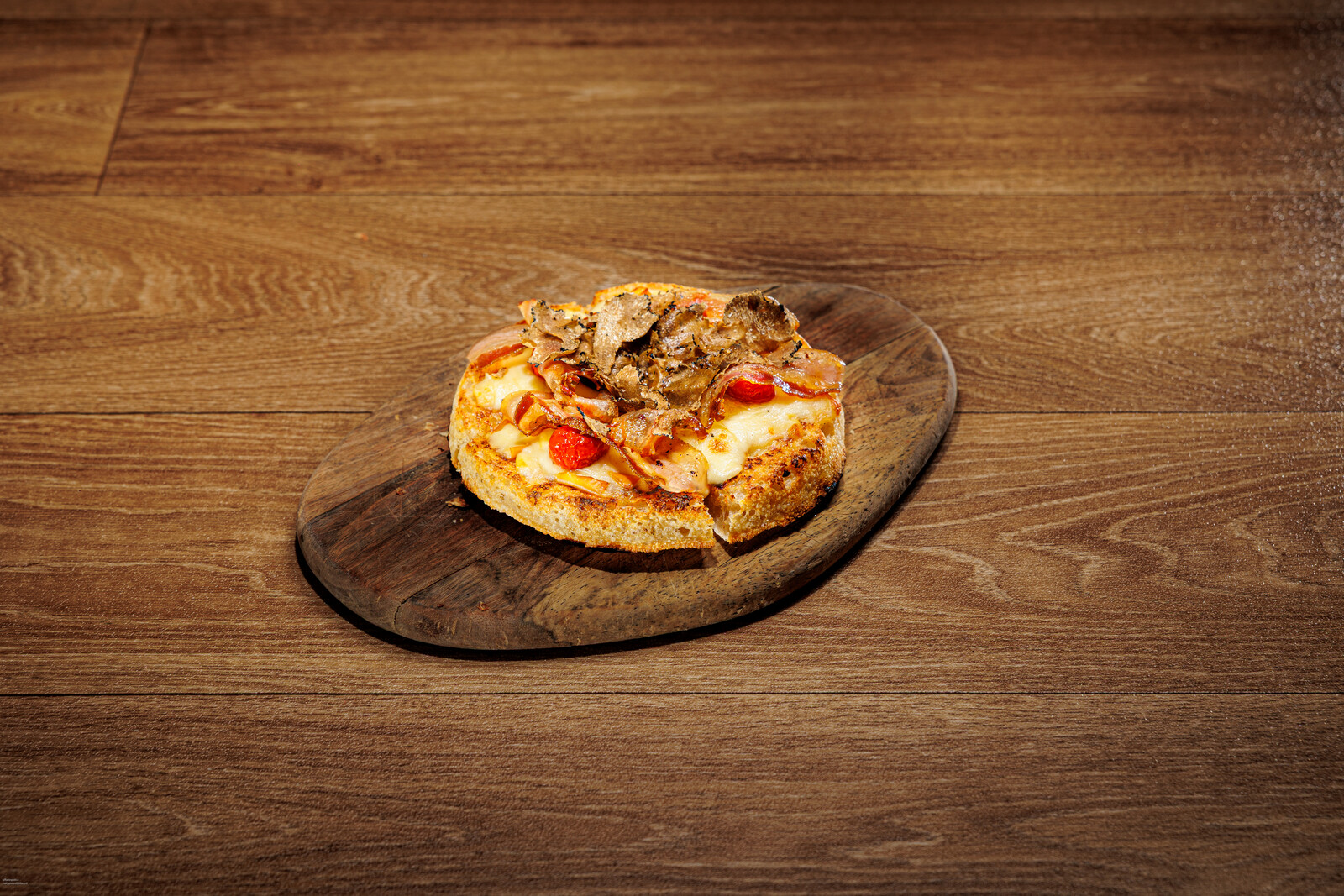 Focaccia tonda farcita con pomodorini su tagliere