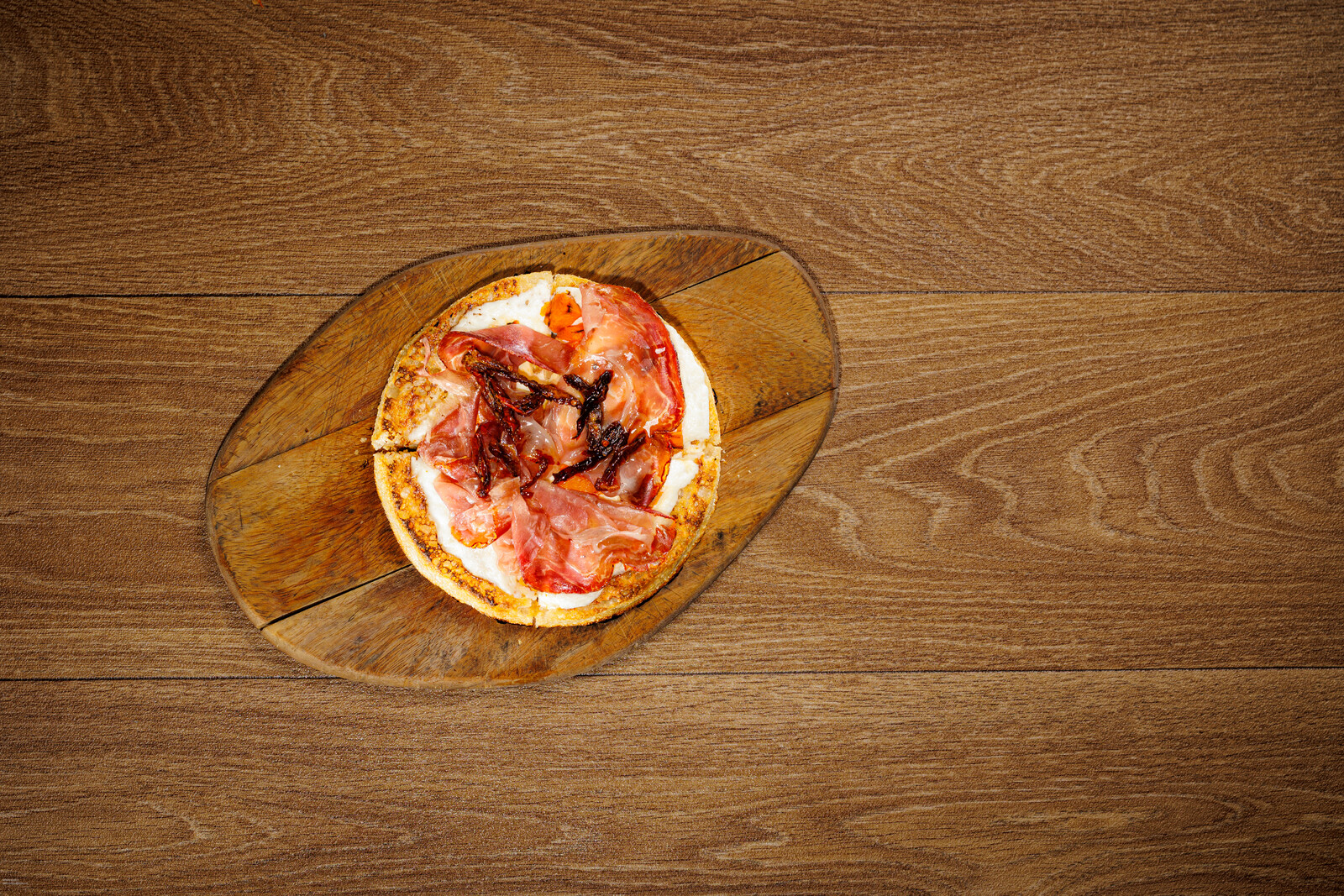 Focaccia tonda con salumi su tagliere di legno