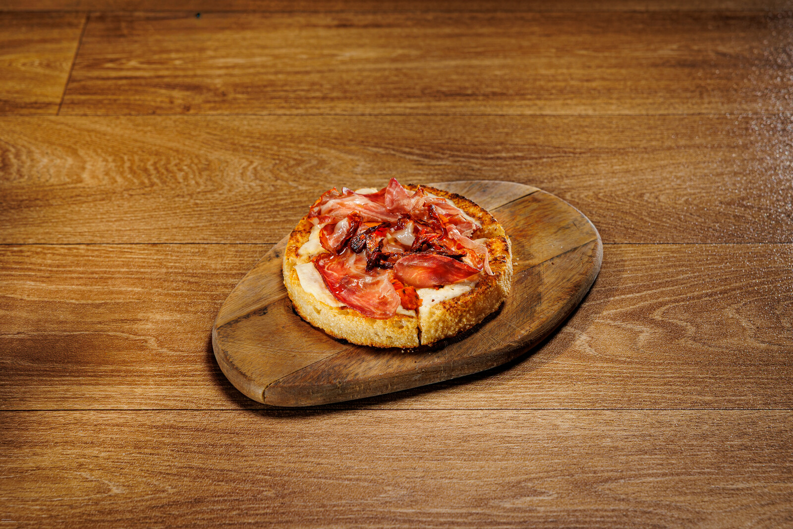 Focaccia tonda con salumi vista dall'alto sul tagliere