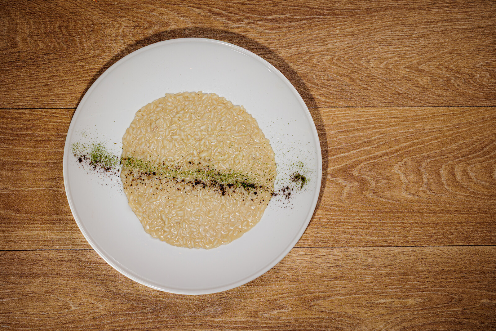 Risotto all'acciuga — Riso Carnaroli La Balocchina, acciuga del Cantabrico, burro affumicato e polvere di lime nero