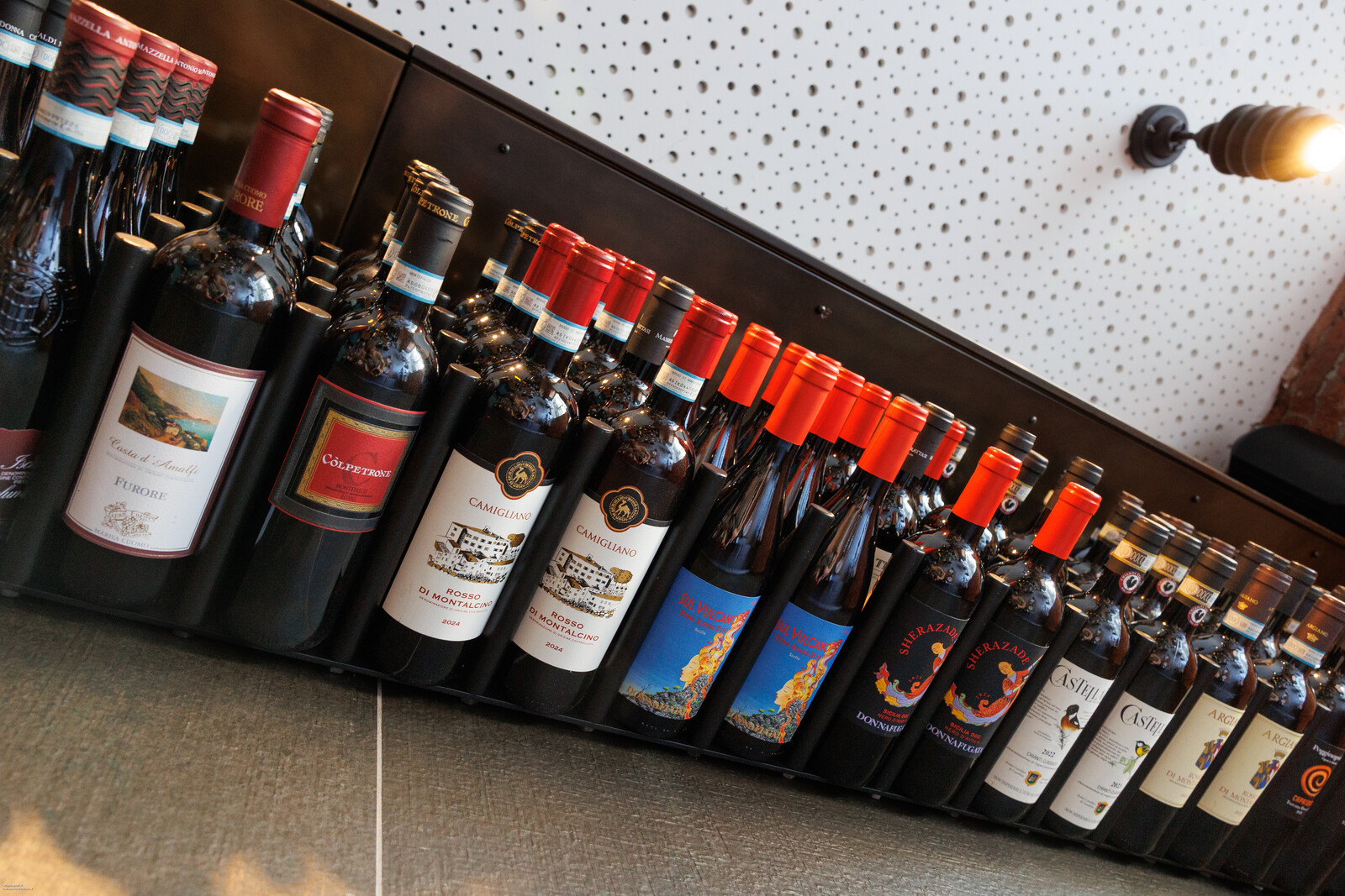 Bottiglie sui ripiani inclinati della cantina